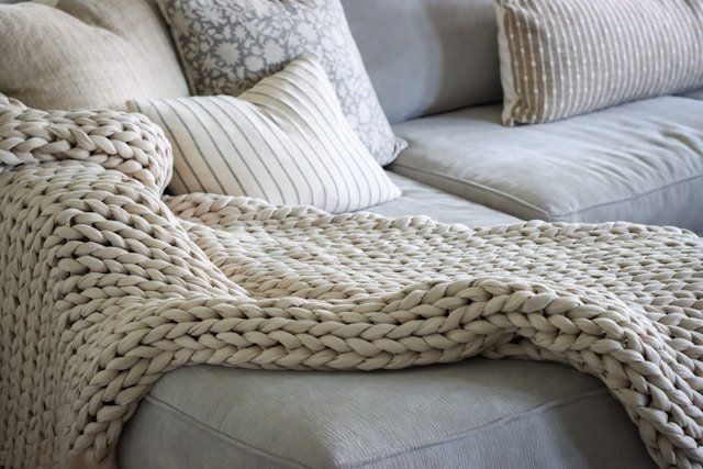 A couch with a blanket on top of it